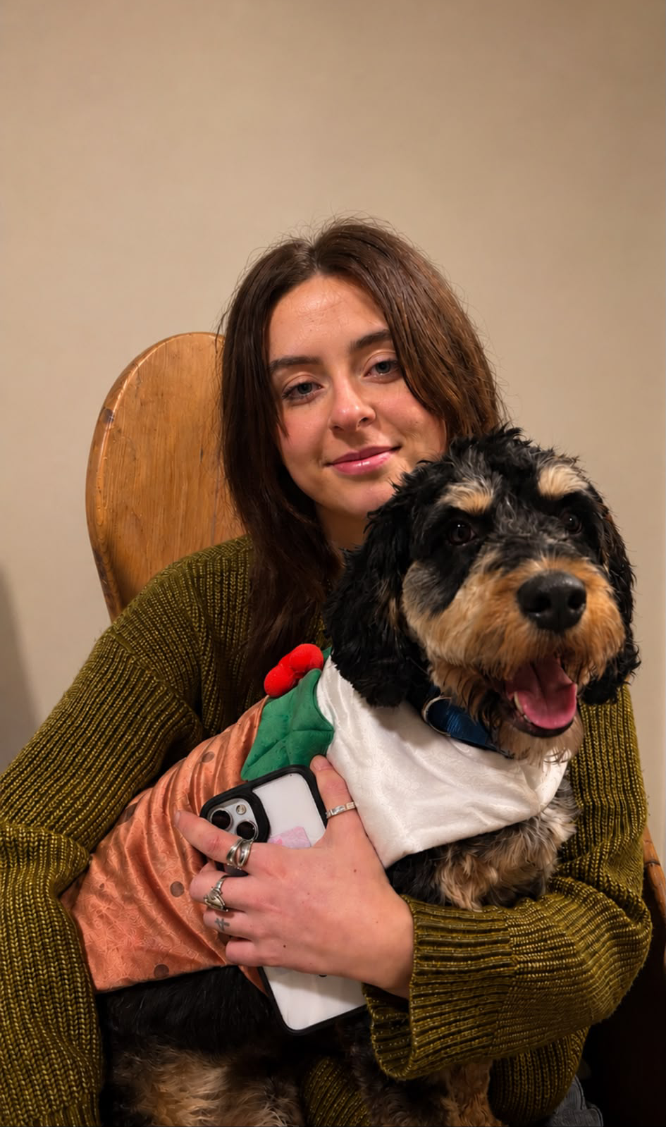 A woman with a black and tan dog on her knee.